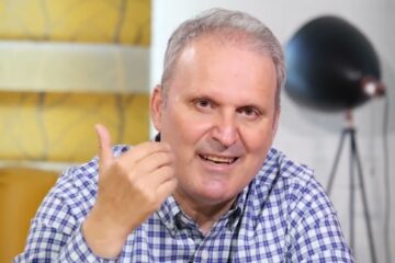 A man giving a thumbs up in front of a camera