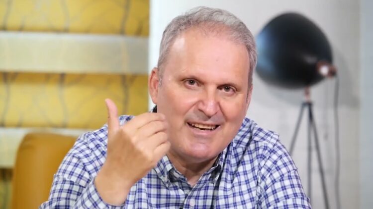 A man giving a thumbs up in front of a camera