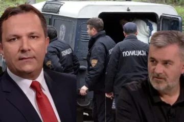 a man in a suit and tie standing in front of a van